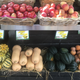 Baskets of produce at a farmers market, including butternut squash